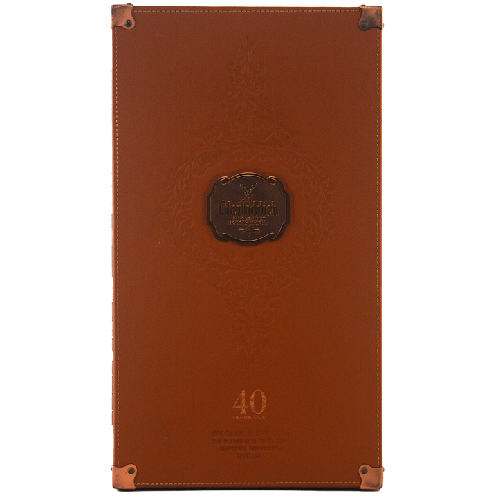 A brown leather case for Glenfiddich 40 Year Old Single Malt Scotch Whisky features embossed patterns, metal corner protectors, and "40 Years Old" at the base. The Glenfiddich logo appears at the center of this elegant limited edition box.