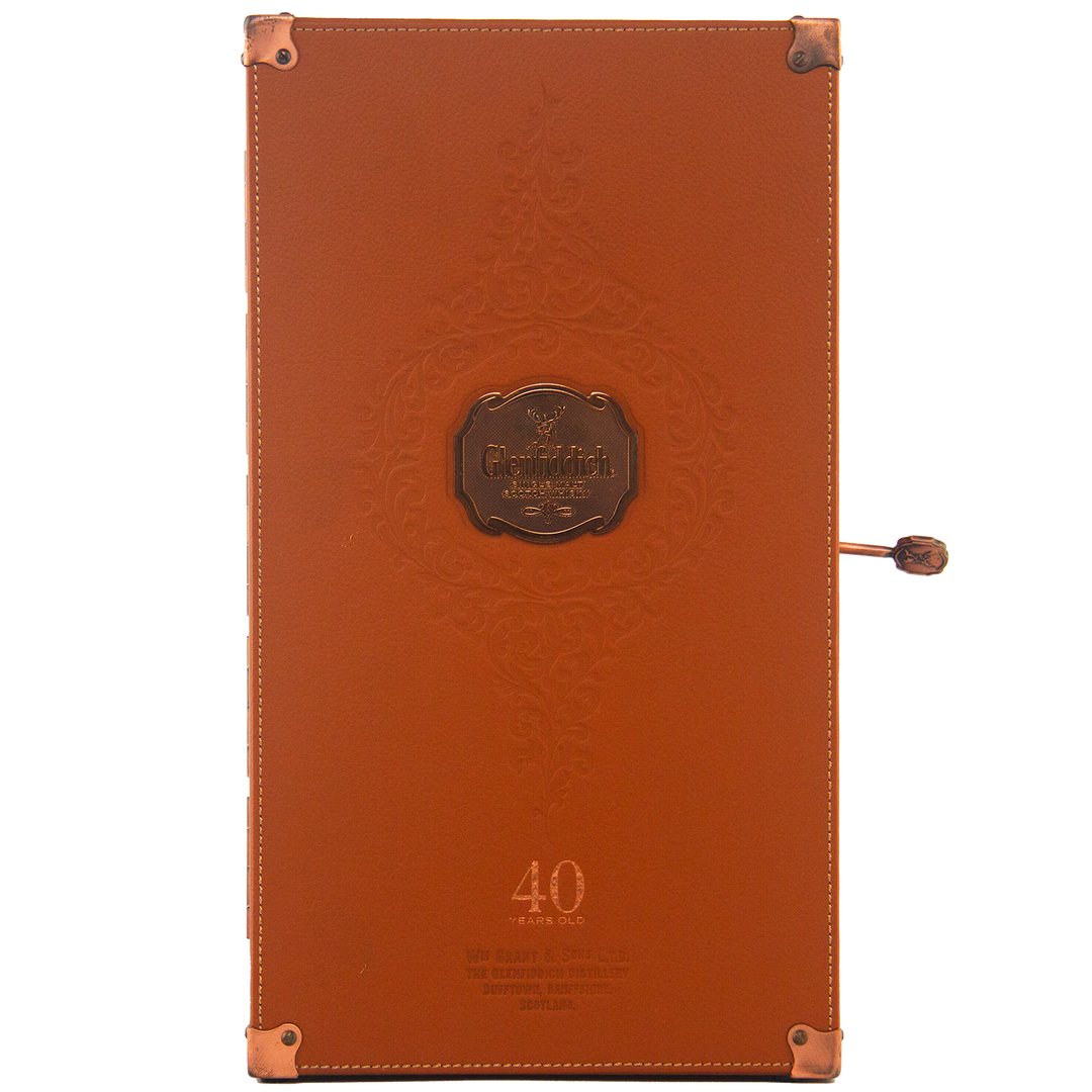 Rectangular brown leather box with embossed designs, copper-colored corners, and a metal plaque reading Glenfiddich 40 Year Old Single Malt Scotch Whisky—a refined case for this limited edition Speyside single malt.