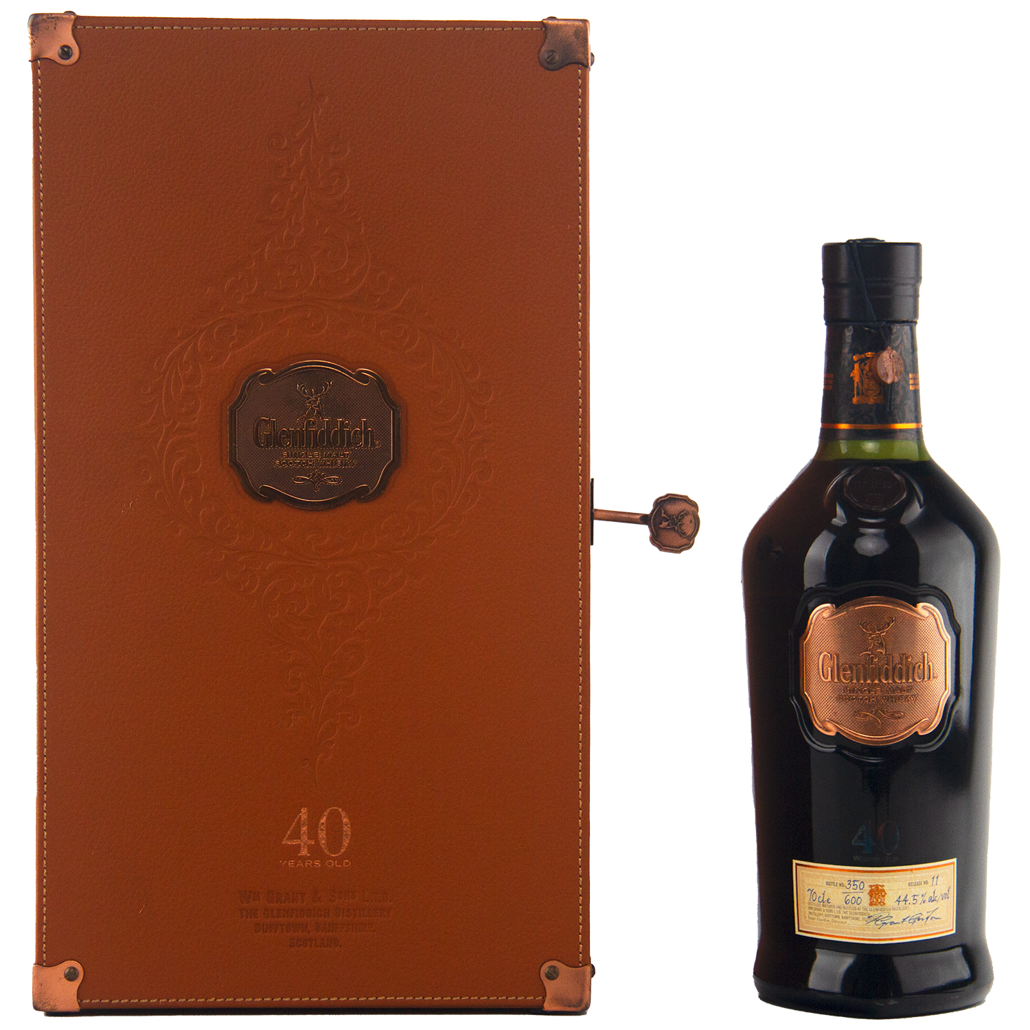 A Glenfiddich 40 Year Old Single Malt Scotch Whisky bottle in dark glass with a copper label is displayed beside an elegant brown leather case with embossed details and copper accents—an extraordinary limited edition release.