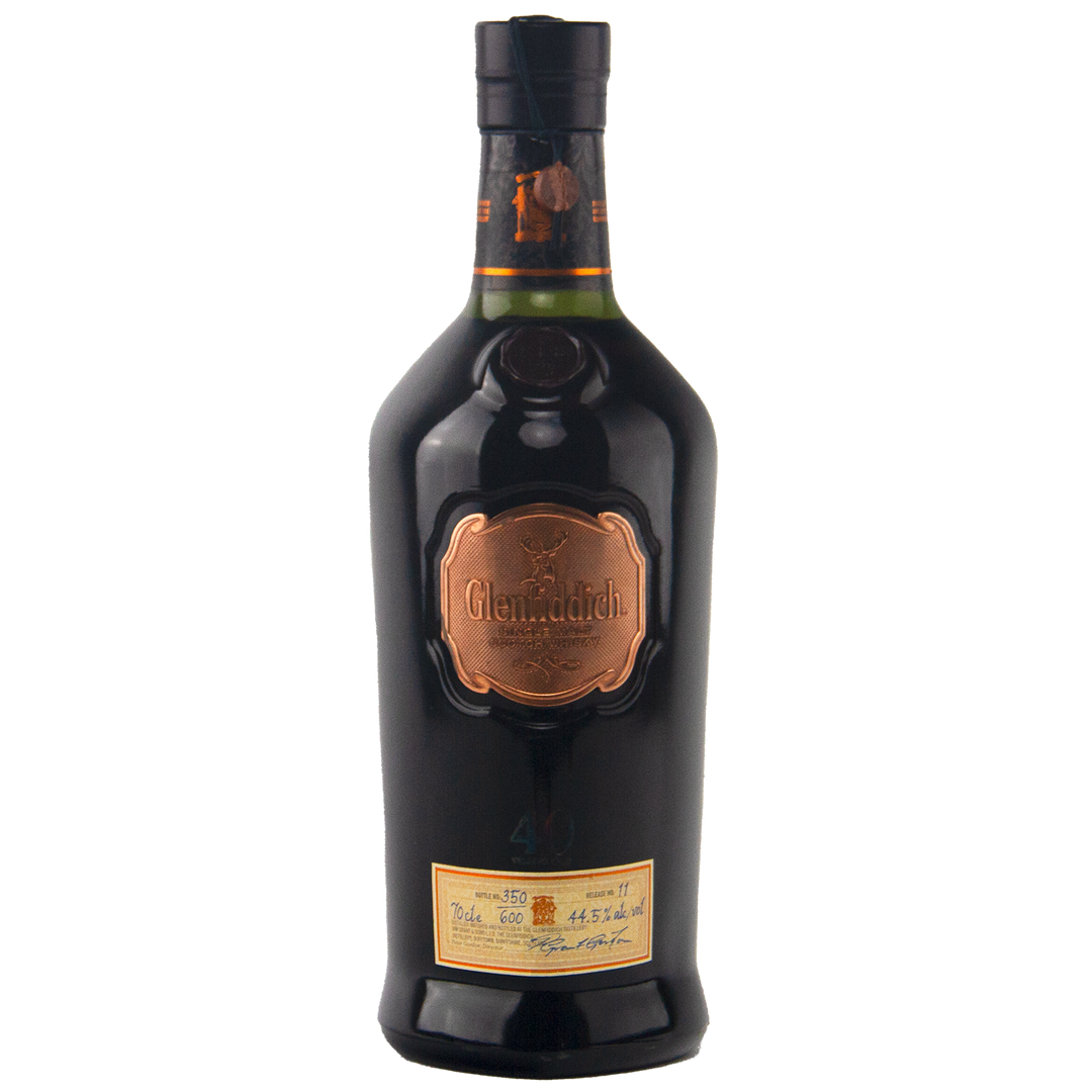 A dark bottle of Glenfiddich 40 Year Old Single Malt Scotch Whisky features a copper label and a cream label near the base, both presenting the limited edition’s details in cursive and print.