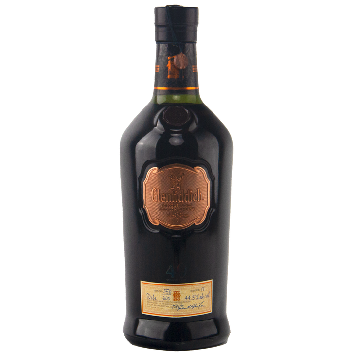A dark bottle of Glenfiddich 40 Year Old Single Malt Scotch Whisky features a copper label and a cream label near the base, both presenting the limited edition’s details in cursive and print.