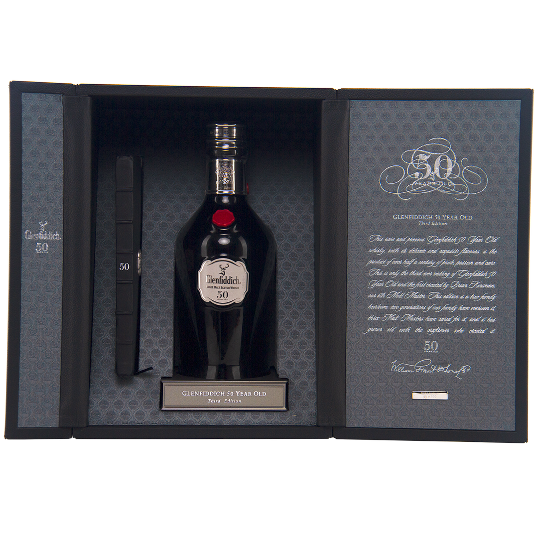 A luxury box featuring Glenfiddich 50 Year Old Single Malt Scotch Whisky (Third Edition), with patterned lining, a certificate on the left, and a detailed plaque and description on the right.