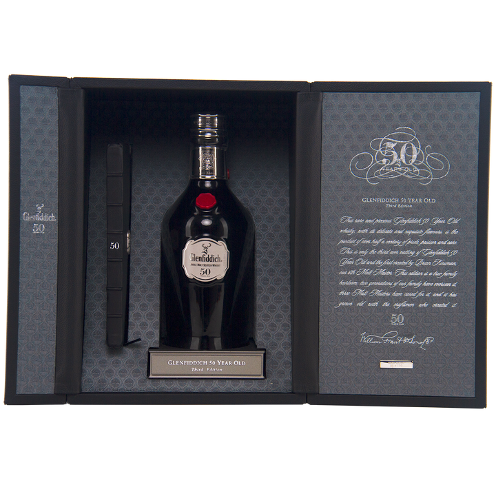 A luxury box featuring Glenfiddich 50 Year Old Single Malt Scotch Whisky (Third Edition), with patterned lining, a certificate on the left, and a detailed plaque and description on the right.