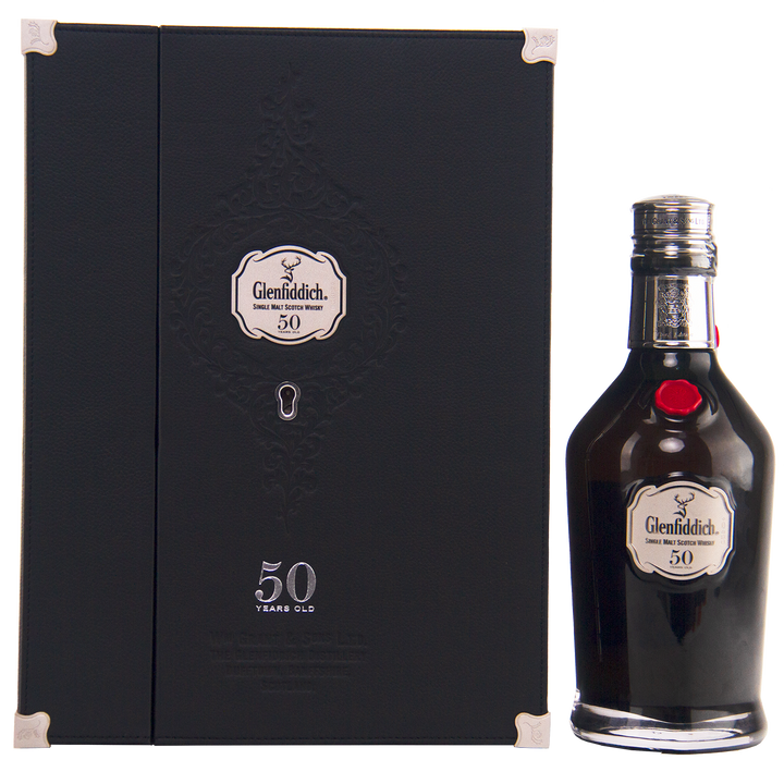 A bottle of Glenfiddich 50 Year Old Single Malt Scotch Whisky (Third Edition) stands by its elegant black box, both adorned with silver Glenfiddich logos and "50 Years Old" text—a rare collector’s whisky.