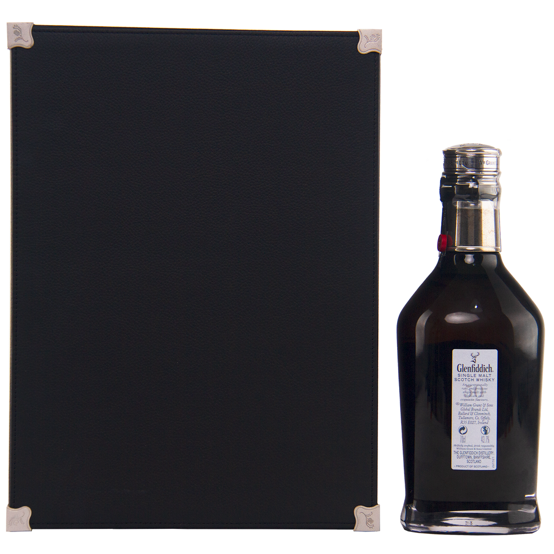 A black rectangular box with silver corners stands beside the uniquely shaped Glenfiddich 50 Year Old Single Malt Scotch Whisky (Third Edition) bottle, which features a blue label and silver cap, set against a plain white background.