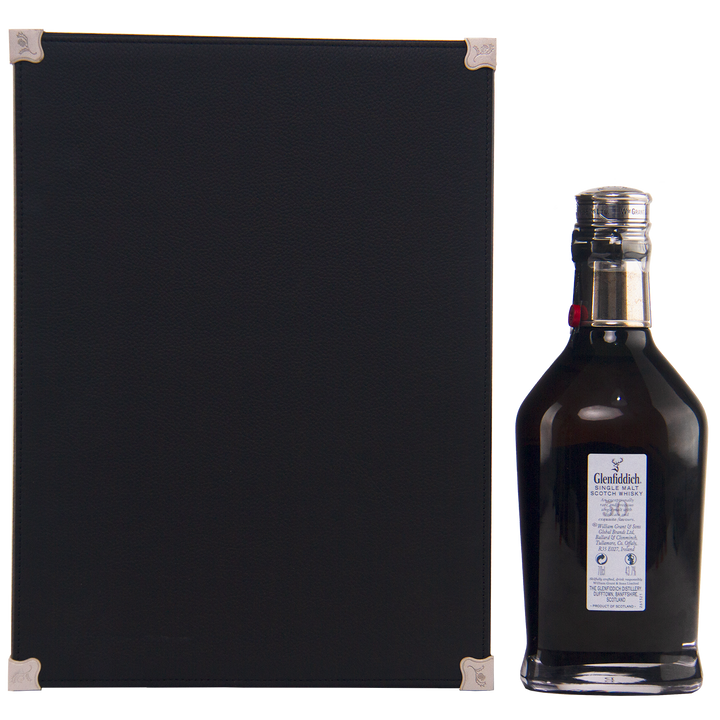 A black rectangular box with silver corners stands beside the uniquely shaped Glenfiddich 50 Year Old Single Malt Scotch Whisky (Third Edition) bottle, which features a blue label and silver cap, set against a plain white background.