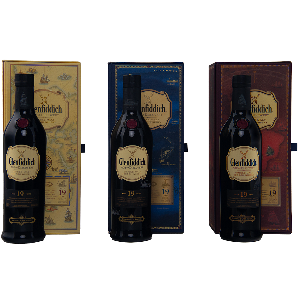 Three bottles of Glenfiddich Age of Discovery Collection Single Malt Scotch Whisky are arranged side by side, each in front of a distinctive yellow, blue, or brown box, creating a striking collector’s set on a light background.