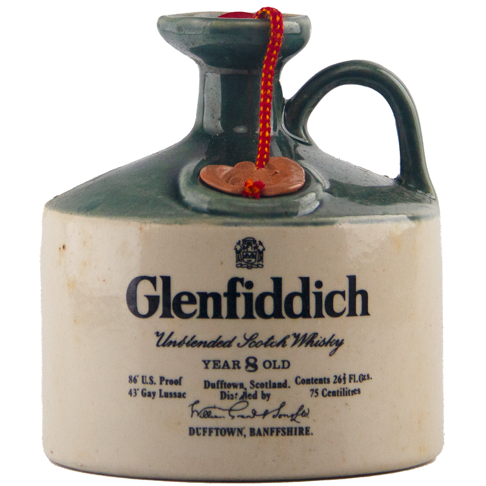 A collectible, the Glenfiddich 8 Year Old Still Master’s Crock Decanter 1970 Single Malt Scotch Whisky features a ceramic jug with a green neck, handle, red cord, and label highlighting its single malt Dufftown origins.