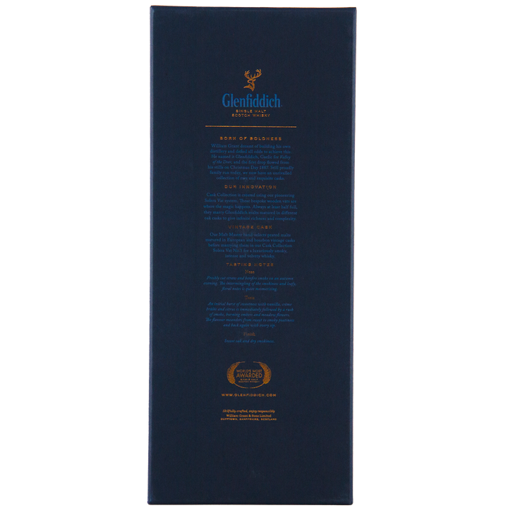 The back of the Glenfiddich Vintage Cask Single Malt Scotch Whisky box features dark blue and gold text, the Glenfiddich logo at the top, plus awards and travel retail exclusive website information below.
