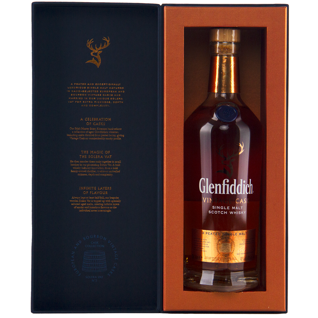 A bottle of Glenfiddich Vintage Cask Single Malt Scotch Whisky in a gift box with gold and orange accents, featuring a gold label, stag logo, and text highlighting its unique cask heritage.