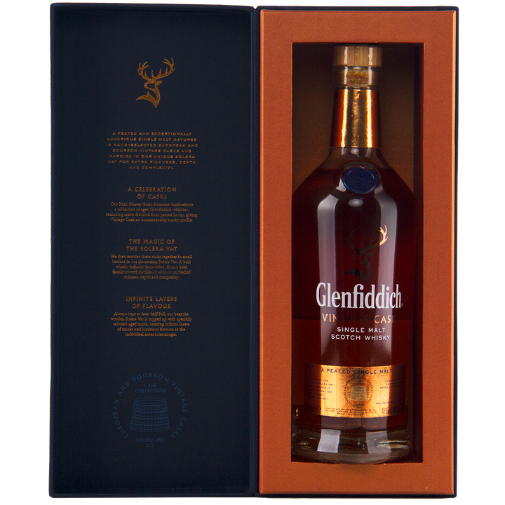A bottle of Glenfiddich Vintage Cask Single Malt Scotch Whisky in a gift box with gold and orange accents, featuring a gold label, stag logo, and text highlighting its unique cask heritage.
