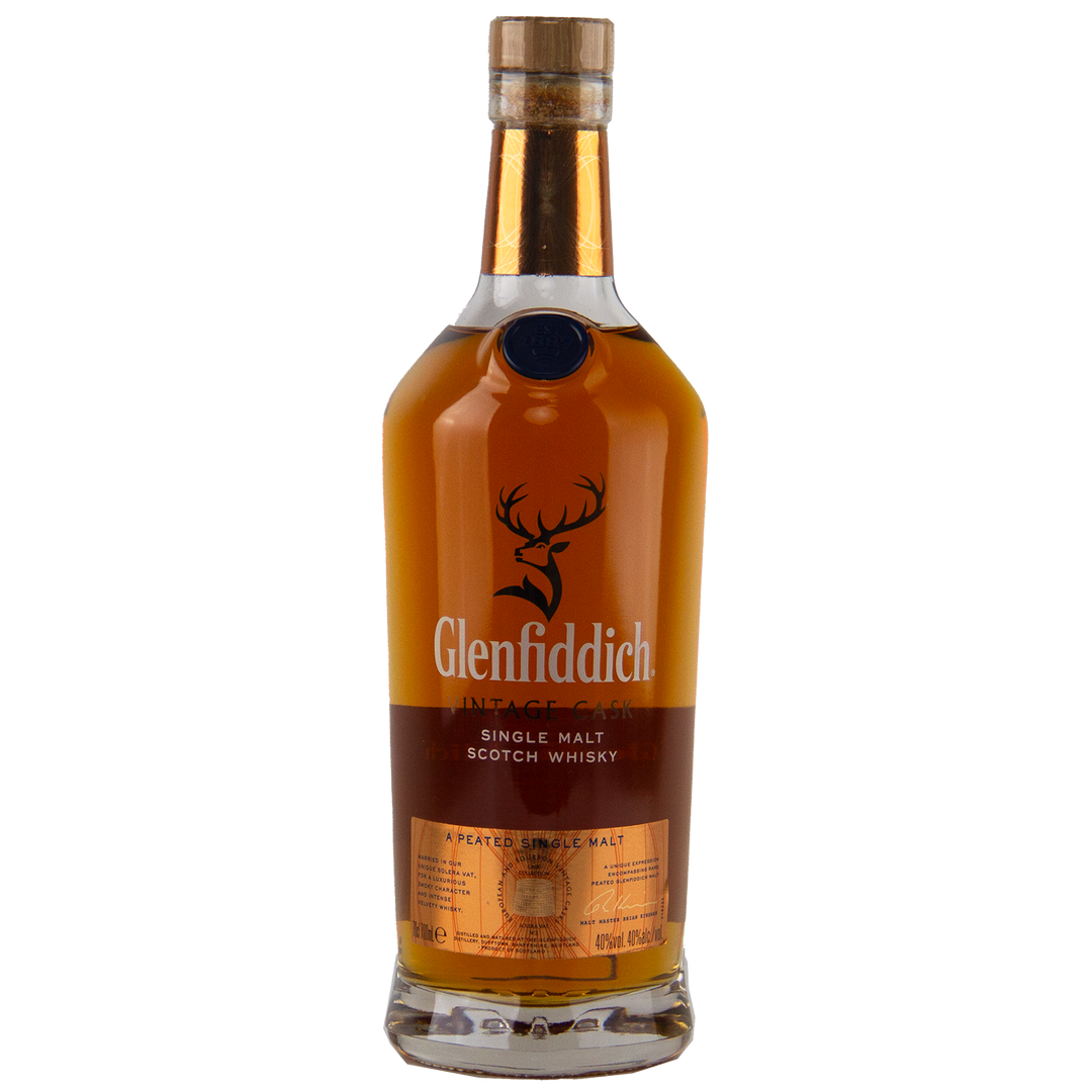 A bottle of Glenfiddich Vintage Cask Single Malt Scotch Whisky with an amber liquid, brown label, and wooden cap stands upright on a white background—ideal as a travel retail exclusive.