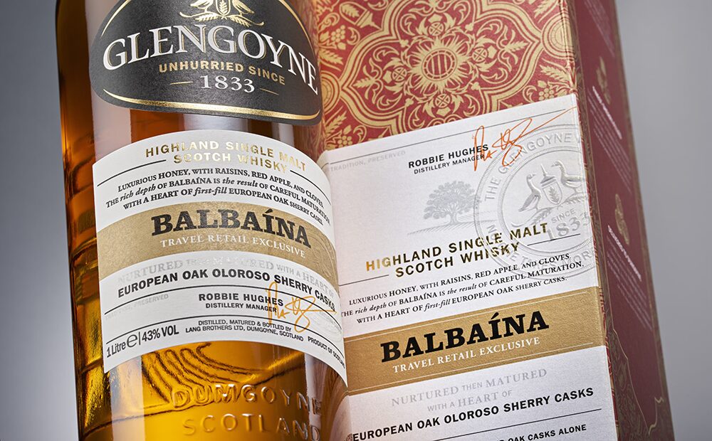 A close-up of a Glengoyne Balbaina Single Malt Scotch Whisky bottle and packaging, showcasing gold accents, the Balbaina label, and details of sherry cask maturation in European oak Oloroso barrels.