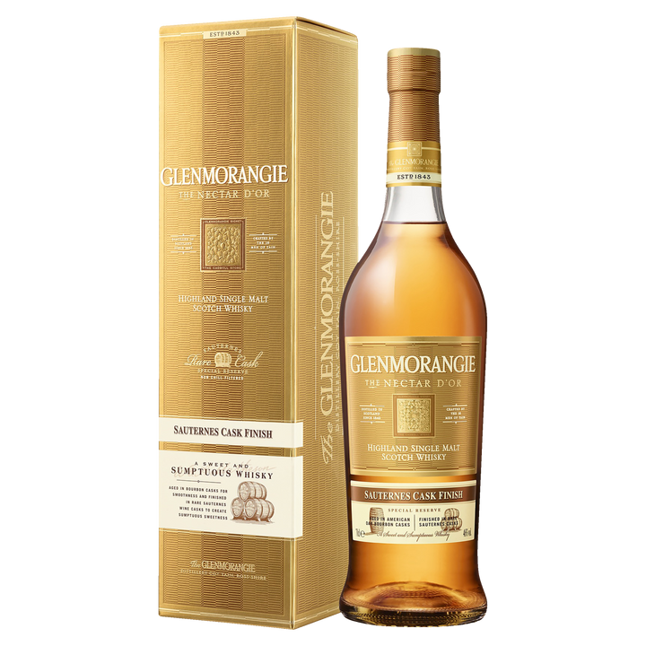 A bottle of Glenmorangie Nectar D’Or Sauternes Cask Finish Single Malt Scotch Whisky stands beside its gold-colored box, both featuring elegant gold and white text and detailing.