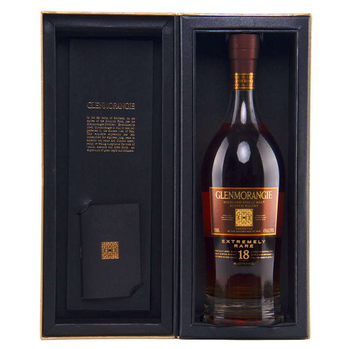 A bottle of Glenmorangie 18 Year Old Extremely Rare (Older Packaging) Highland single malt Scotch whisky displayed in an open black gift box with gold detailing and an inscription inside the cover.