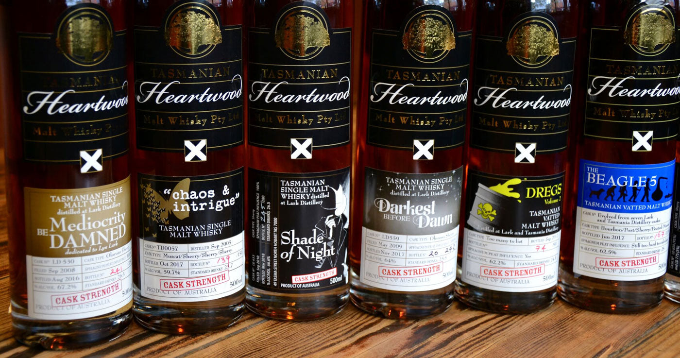 Collection of Heartwood Tasmania whisky bottles on a wooden surface