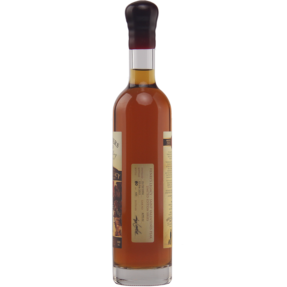 A tall, clear glass bottle filled with amber liquid, sealed with a dark cap and a rectangular side label—this is Hellyers Road Saint Valentines Peak Australian Single Malt Whisky.