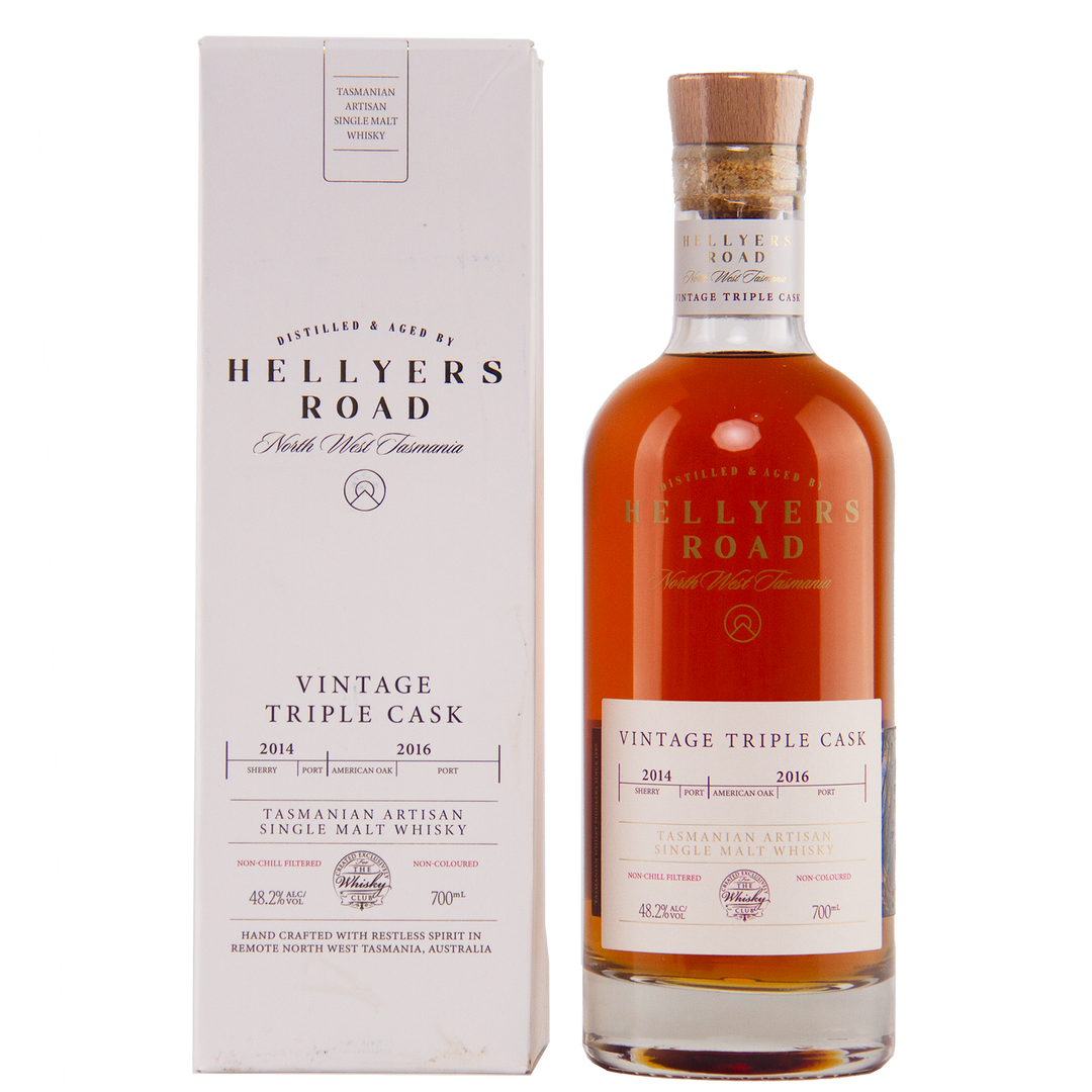 A bottle of Hellyers Road Vintage Triple Cask Australian Single Malt Whisky stands beside its white box, both adorned with gold and red lettering highlighting cask years, origin, and volume—an exclusive for The Whisky Club.