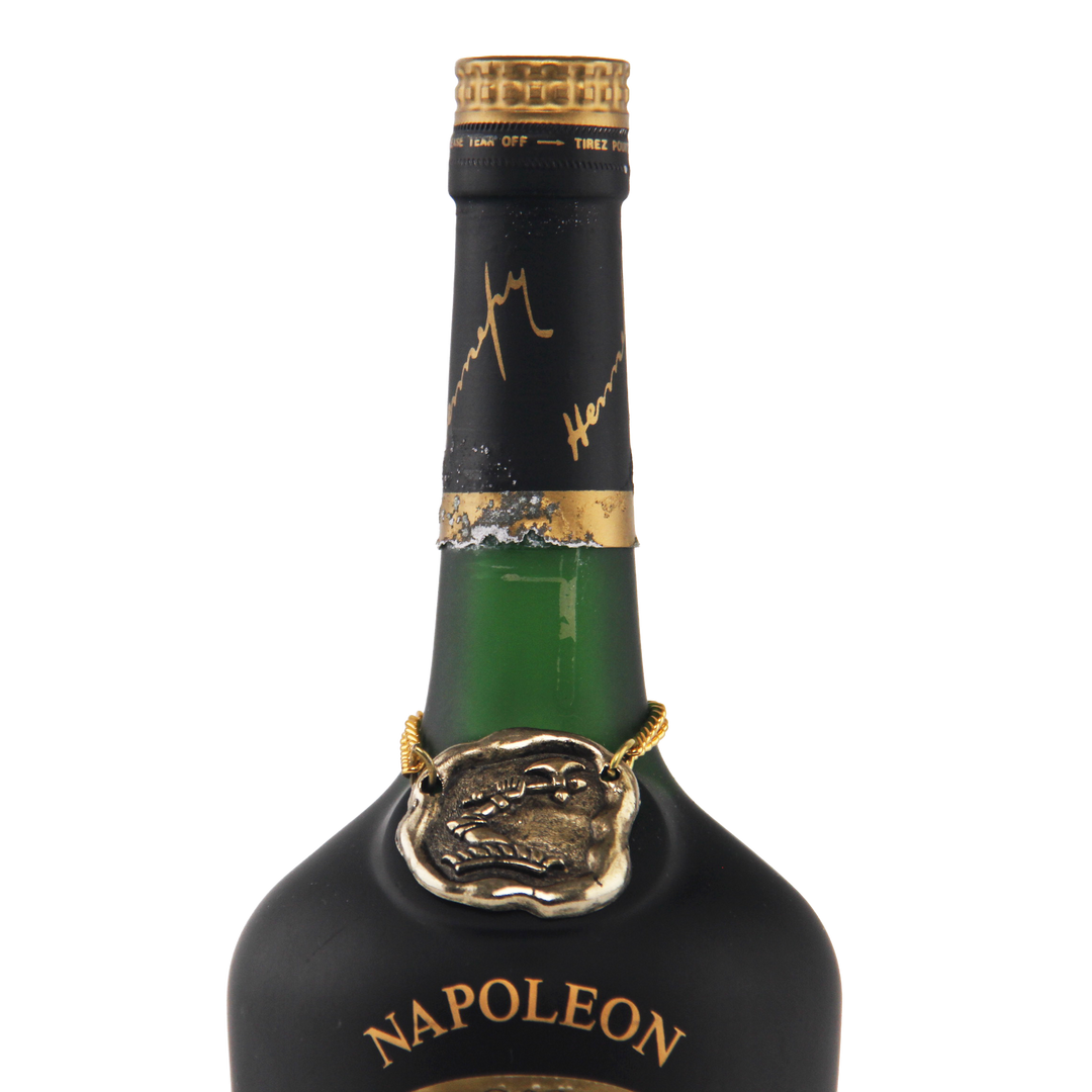 Bottle of Napoleon brand liquor with gold cap and label on a white background