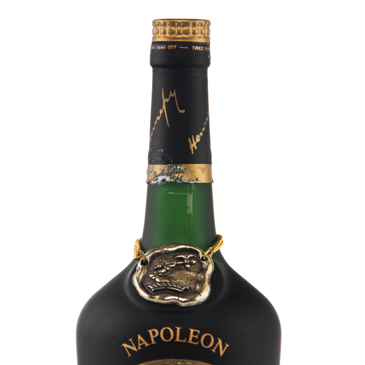 Bottle of Napoleon brand liquor with gold cap and label on a white background