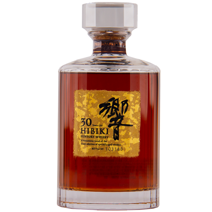 A bottle of Hibiki 30 Year Old Japanese Blended Malt Whisky features dark amber liquid, a gold label with black Japanese and English text, and a faceted glass stopper.