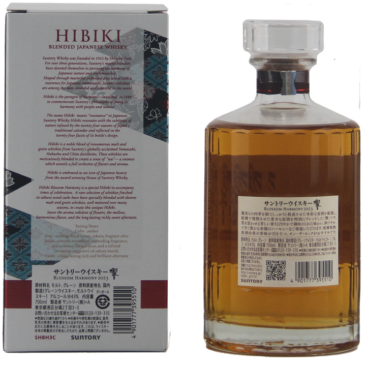 A bottle of Hibiki Blossom Harmony 2023 Japanese Blended Malt Whisky sits beside its box featuring product details and Japanese text. The tall bottle displays a clear label and contains the amber liquid of this limited edition release.