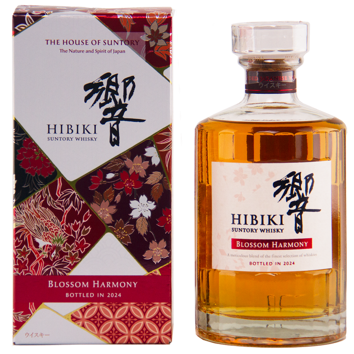 A bottle of Hibiki Blossom Harmony 2024 Limited Edition Japanese whisky stands beside its floral-patterned box, featuring a clear label and golden liquid, with red, gold, and white blossoms evoking the elegance of sakura cask aging.