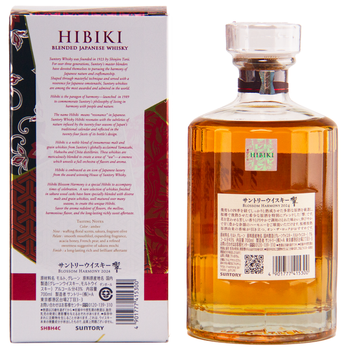 A bottle of Hibiki Blossom Harmony 2024 Limited Edition whisky beside its box. The clear bottle has a patterned label and stopper; the box showcases tasting notes and sakura cask details in English and Japanese.
