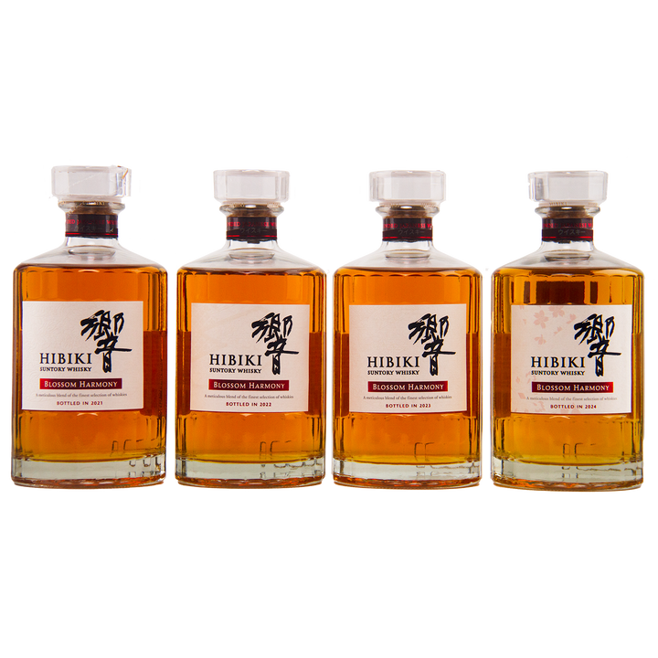 Four bottles from the Hibiki Blossom Harmony Limited Edition Collection 2021 to 2024 stand side by side against a white background, each displaying its clear label and amber liquid—exemplifying Suntory's signature artistry.