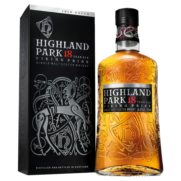 A bottle of Highland Park 18 Year Old Single Malt Scotch Whisky stands beside its ornate black box, both showcasing Norse-inspired designs accented with gold, white, and red text.