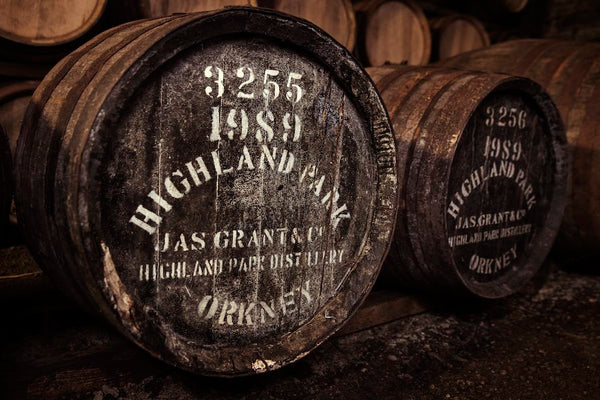 Wooden barrels with 'Highland Park' branding in a storage setting