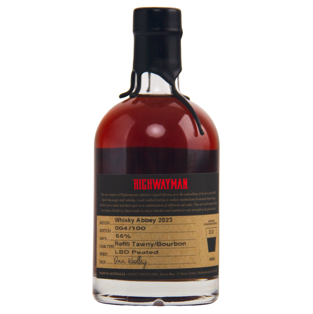 A limited-edition bottle of Highwayman Whisky Abbey 2023 features a black wax-sealed top, dark amber Australian whisky (56% ABV), cask type info, batch number, and a handwritten signature on the label.
