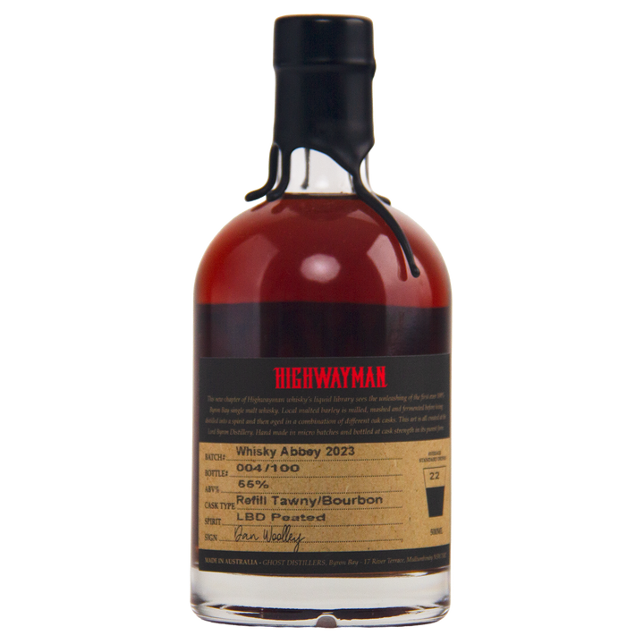 A limited-edition bottle of Highwayman Whisky Abbey 2023 features a black wax-sealed top, dark amber Australian whisky (56% ABV), cask type info, batch number, and a handwritten signature on the label.