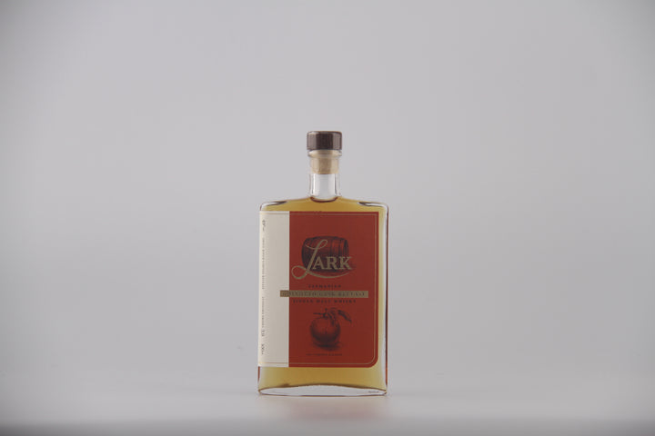 A bottle of Lark brand liquor with a red label and gold lettering, set against a plain light gray background.