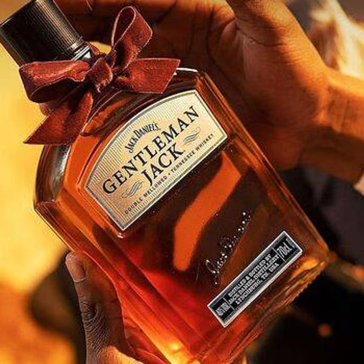 Bottle of Jack Daniel's Gentleman Jack whiskey held by a person with a blurred background