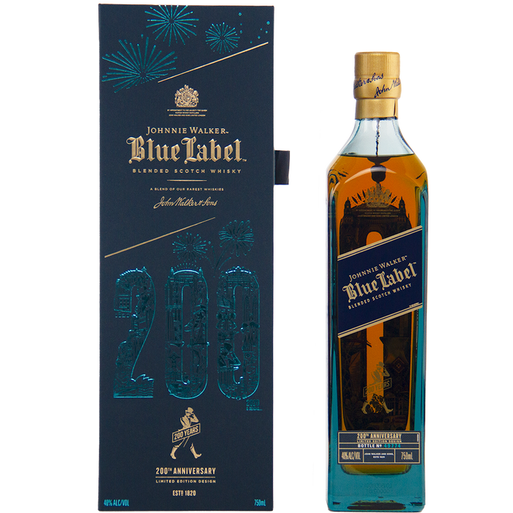 A bottle of Johnnie Walker Blue Label 200th Anniversary sits beside its dark blue commemorative box, adorned with gold accents and fireworks designs.