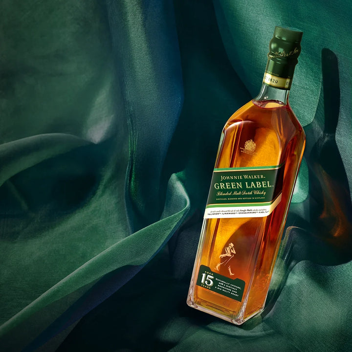 Johnnie Walker Green Label whisky bottle on a dark green fabric background