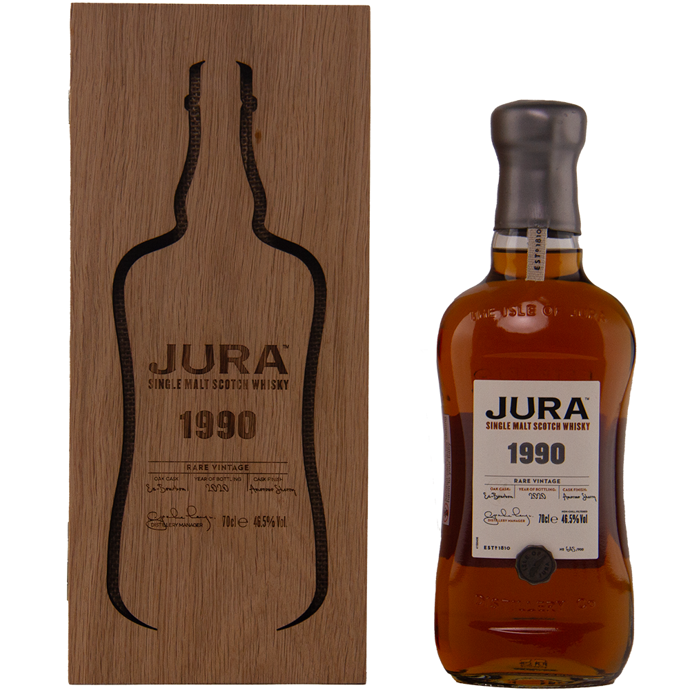 A bottle of Jura 1990 30 Year Old Single Malt Whisky stands beside a wooden box with a bottle-shaped cutout and engraved text. The bottle has a dark wax seal and a white label with black and gold accents—a true collectible Scotch.