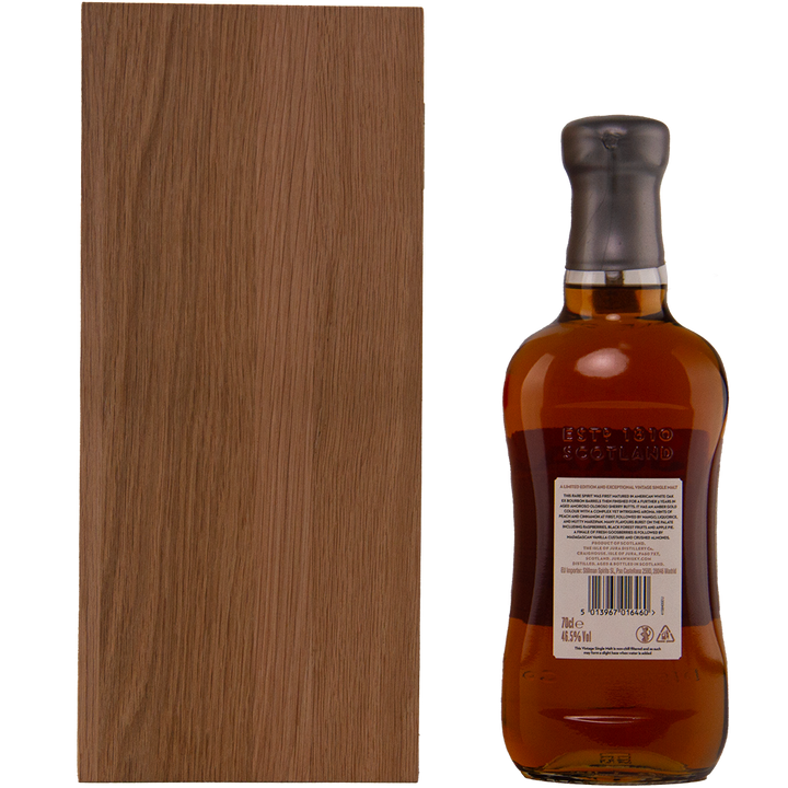 A brown wooden box stands next to a bottle of Jura 1990 30 Year Old Single Malt Whisky with a wax-sealed top, viewed from the back. The bottle shows embossed text and a label with barcode and product details.