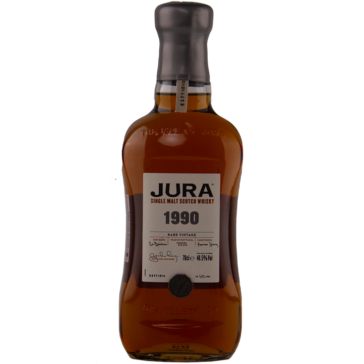 A bottle of Jura 1990 30 Year Old Single Malt Whisky, a collectible single malt with a brown liquid, labeled front, distinctive bottle shape, gray cap, and true limited edition status for whisky connoisseurs.