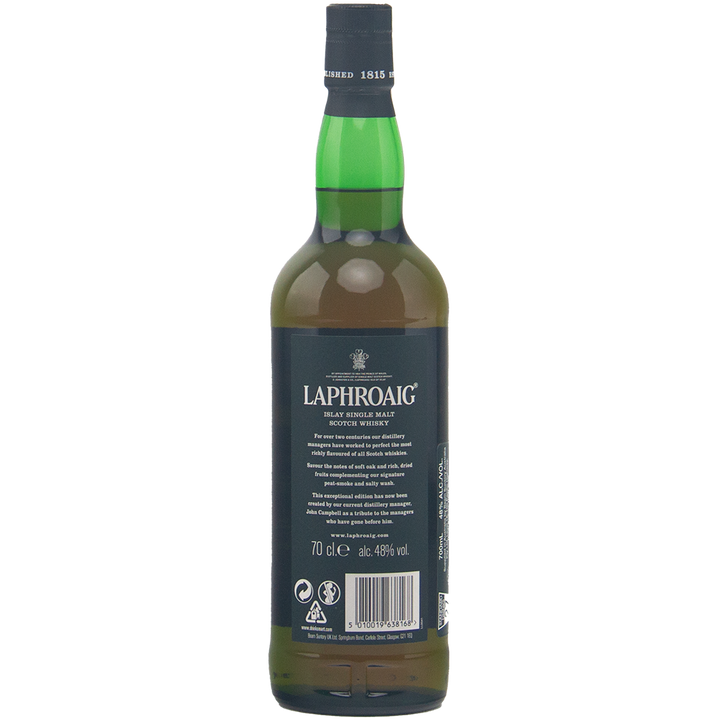 A green glass bottle of Laphroaig 1815 Legacy Edition Single Malt Whisky stands upright, back label with white text visible, black cap on top, photographed against a plain, light background.
