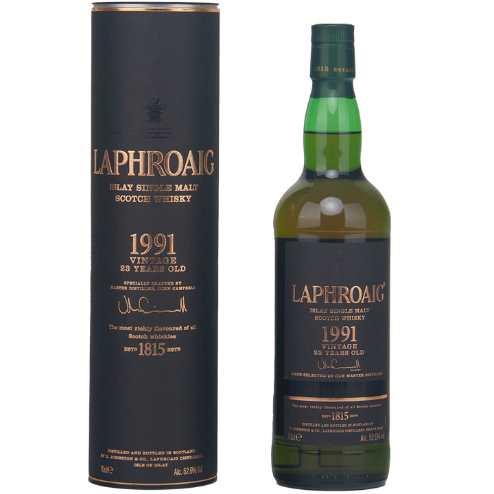 A bottle of Laphroaig 1991 Vintage 23 Year Old Single Malt Whisky stands next to its tall, cylindrical black and gold box, both featuring the product label and whisky details.