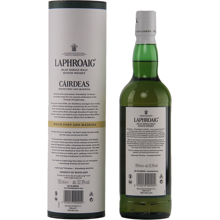 A bottle of Laphroaig Cairdeas White Port and Madeira whisky stands beside its cylindrical white and grey box, both featuring detailed product information and branding in black text.