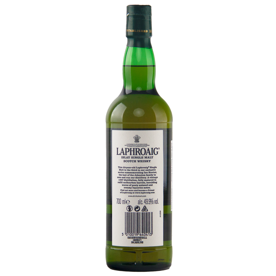 A green glass bottle of Laphroaig Ian Hunter Series Book 3 33 Year Old Single Malt Whisky is shown from the back, revealing the label with product details and barcode. The collectible bottle features a distinctive green and gold foil seal.
