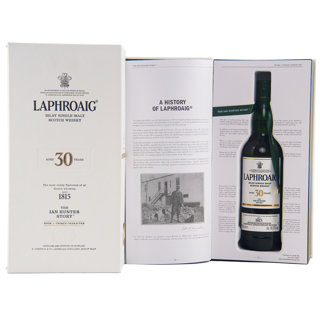 A Laphroaig Ian Hunter Story Book 1 30 Year Old Single Malt Whisky gift box opens to reveal the collector’s bottle and a booklet titled "A History of Laphroaig," featuring a black-and-white photo that celebrates Ian Hunter’s legacy.