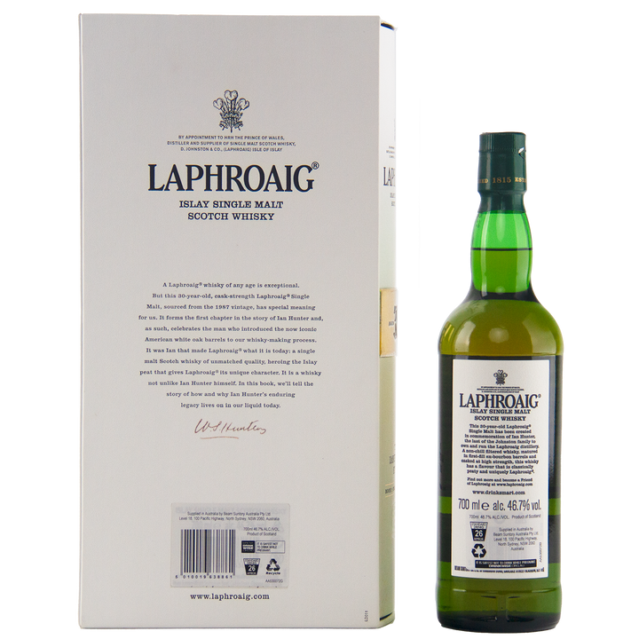 A green bottle of Laphroaig Ian Hunter Story Book 1 30 Year Old Single Malt Whisky stands beside its white box, both displaying the brand and details of this exclusive collector’s edition.