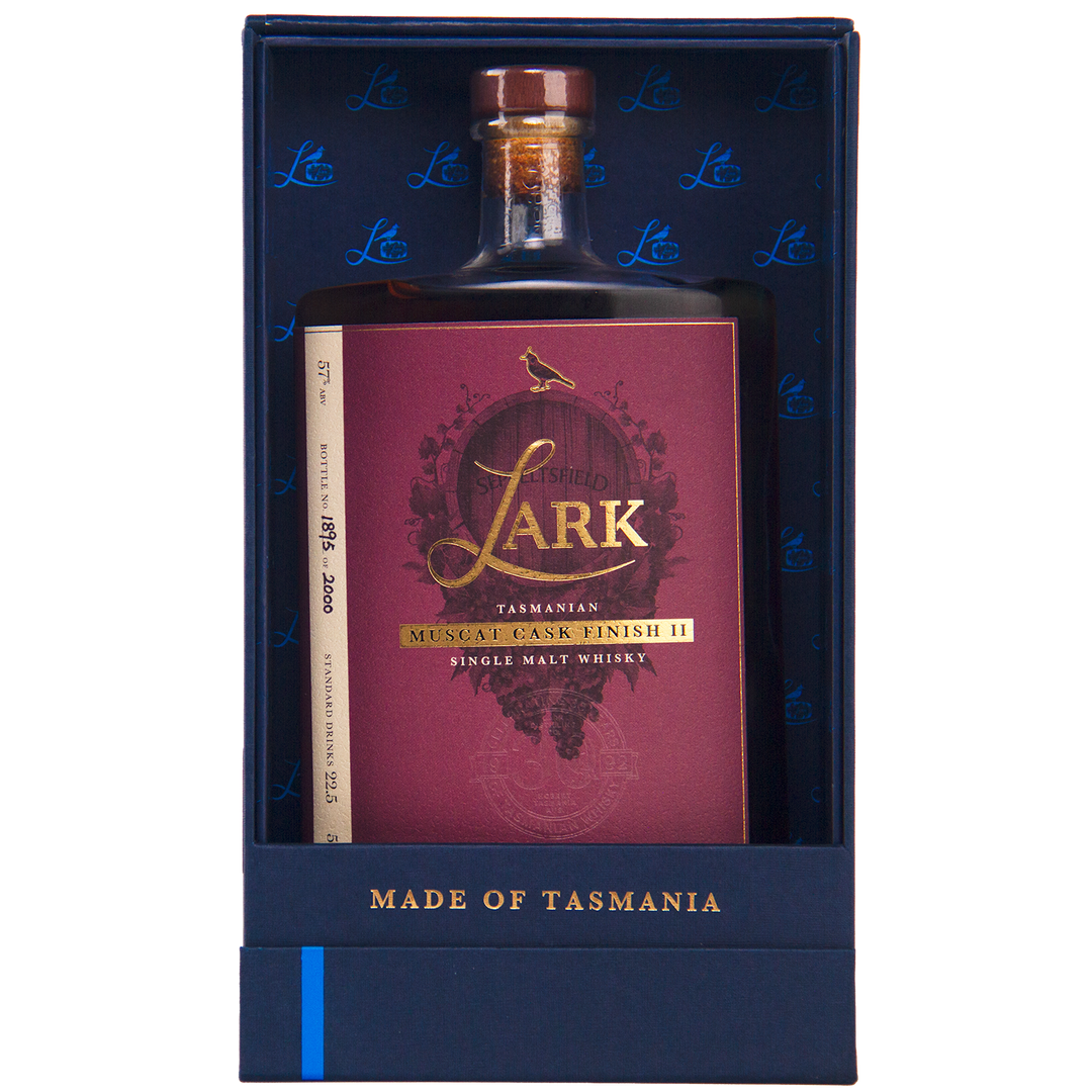 A bottle of Lark Muscat Cask Finish II Single Malt Whisky with a red and gold label stands upright in a blue gift box marked "MADE OF TASMANIA" at the bottom.