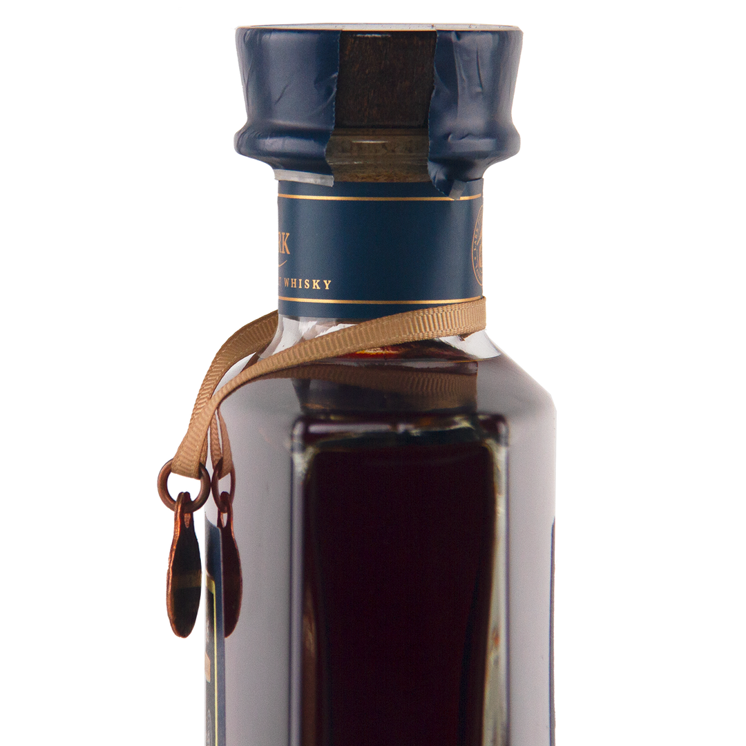 A close-up of the Lark Brokenwood Graveyard Shiraz Rare Cask Single Malt Whisky, featuring a square glass bottle with a blue wax seal, gold ribbon, and dark amber Tasmanian whisky inside against a minimal white background.