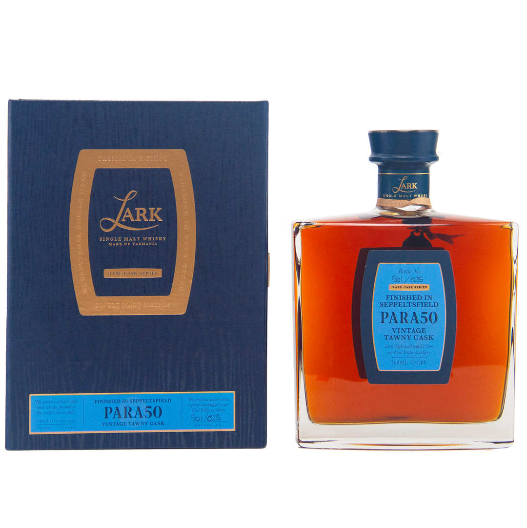 A rectangular dark blue box with gold and blue label sits beside a square bottle of amber Lark Seppeltsfield Para 50 II Rare Cask Single Malt Whisky, a limited edition Australian whisky with a matching blue cap and elegant blue-gold label.