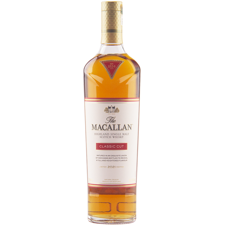 A bottle of The Macallan Classic Cut 2021 Release Single Malt Scotch Whisky features a gold cap and red-and-white label accents, with amber spirit visible through the clear glass in this Highland Scotch edition.